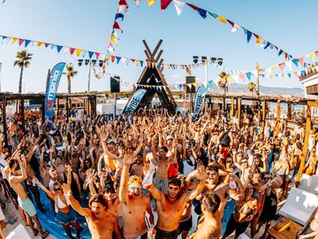 Hands up in front of the DJ booth on a sunny day – Nomad Beach Club, Zrce Beach