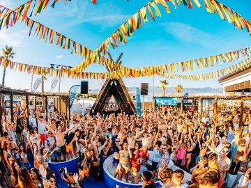 Pool party crowd under colourful flags – Nomad Beach Club, Zrce Beach