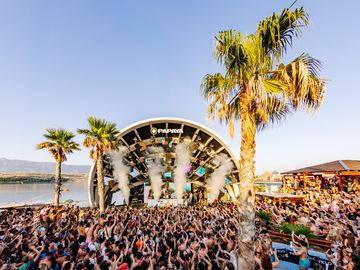 Daytime crowd at the arch stage with palm trees – Papaya Club, Zrće Beach